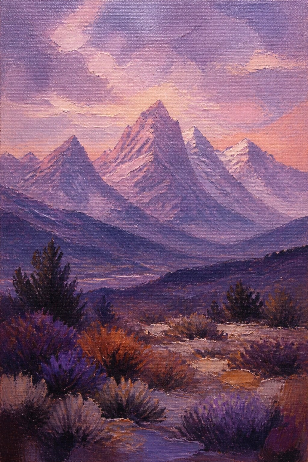 Jagged purple mountains under pink sunset sky with desert shrubs foreground