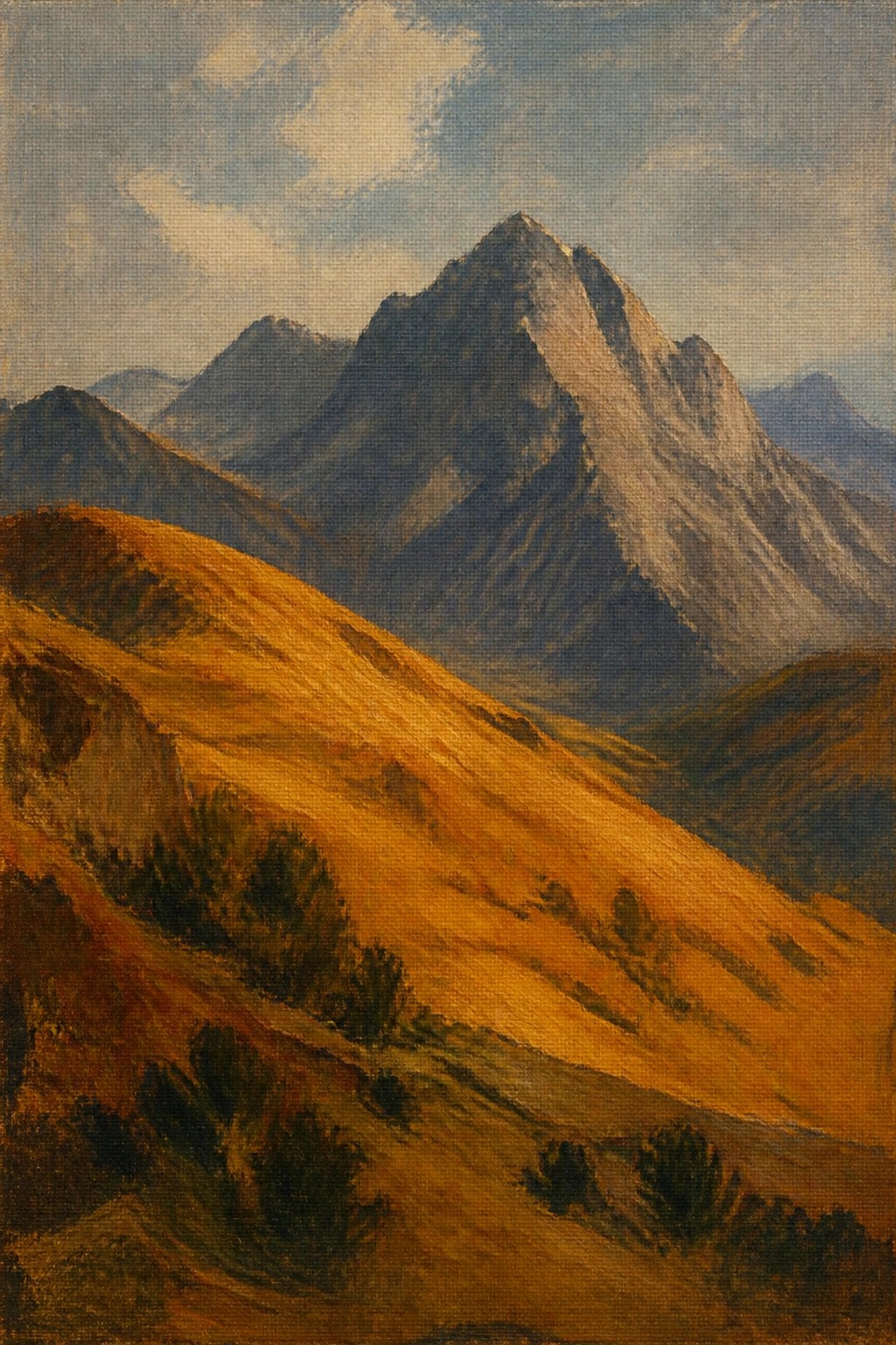 Sunlit golden hills with shrubs lead to jagged mountain peaks under blue sky.