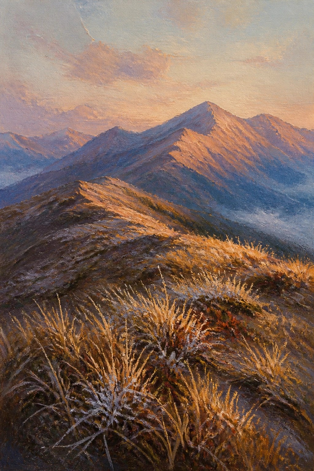 Golden sunlight illuminating rugged mountain ridges above misty valleys with frosty grass.
