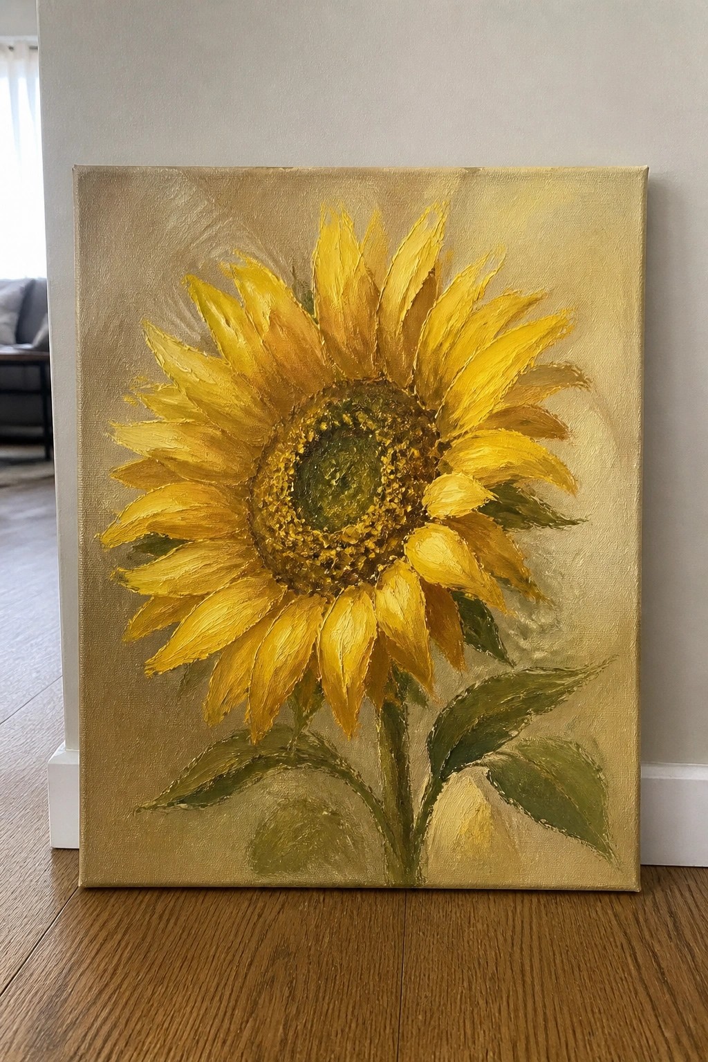 Yellow sunflower painting on canvas leaning against wall on wooden floor