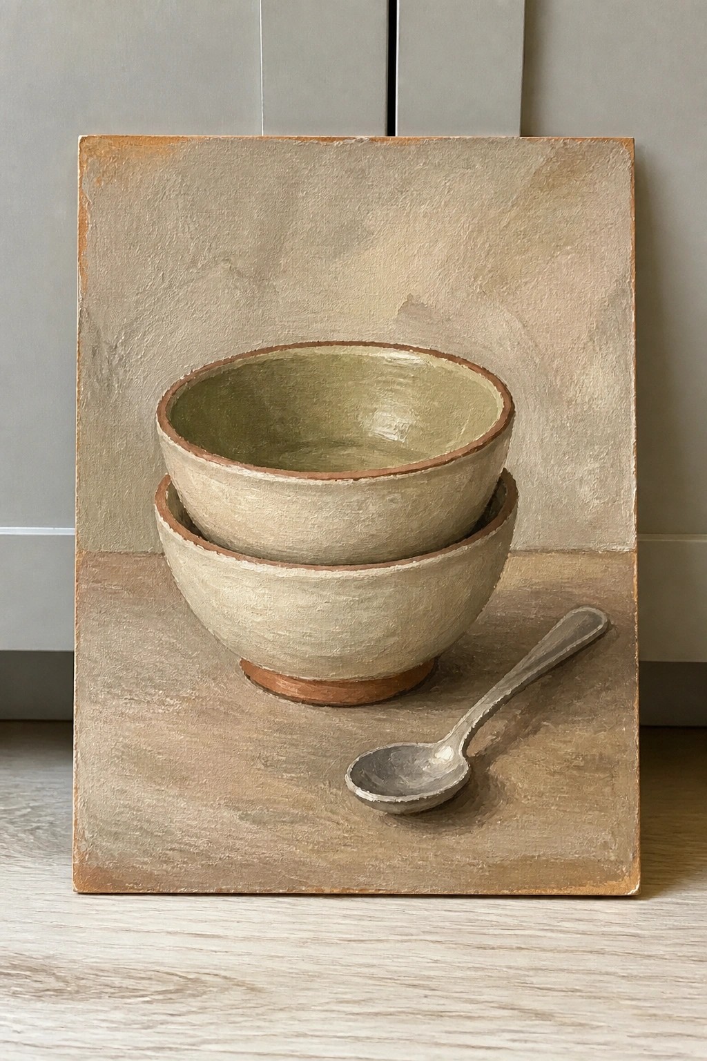 Two stacked ceramic bowls and a spoon on a textured surface
