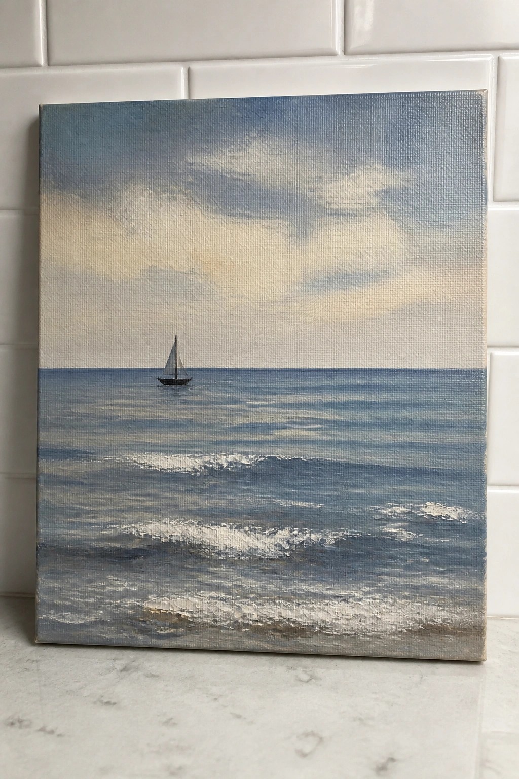 Seascape painting of distant sailboat on blue ocean with white waves and clouds