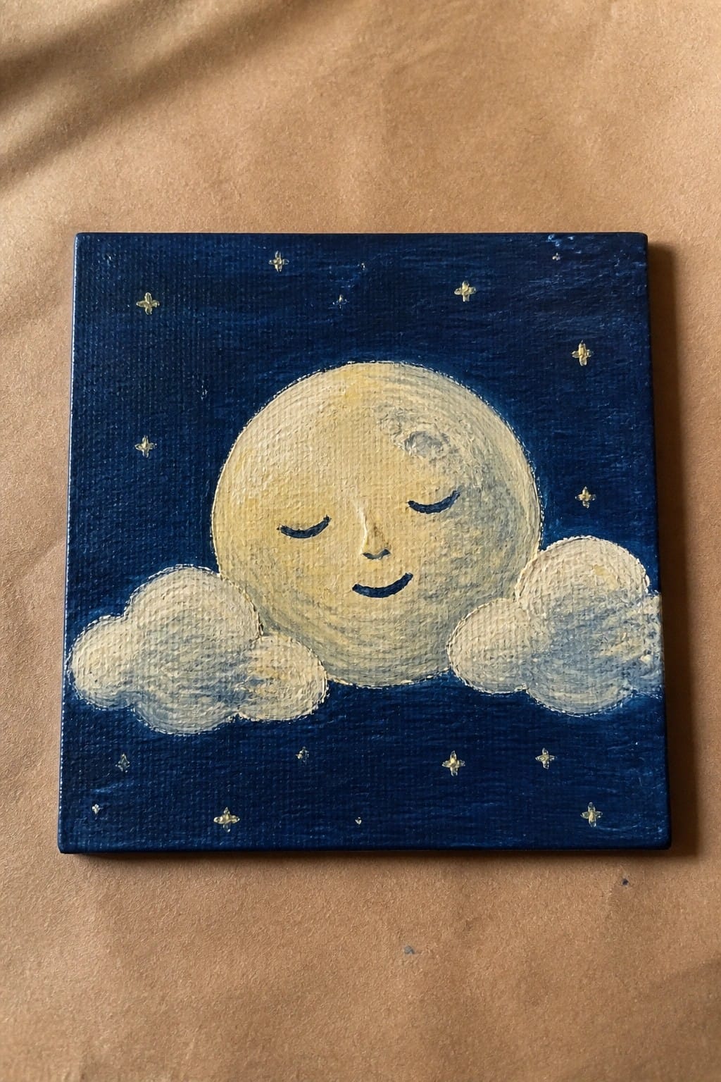 Smiling moon with closed eyes resting on clouds in a dark blue starry sky painting