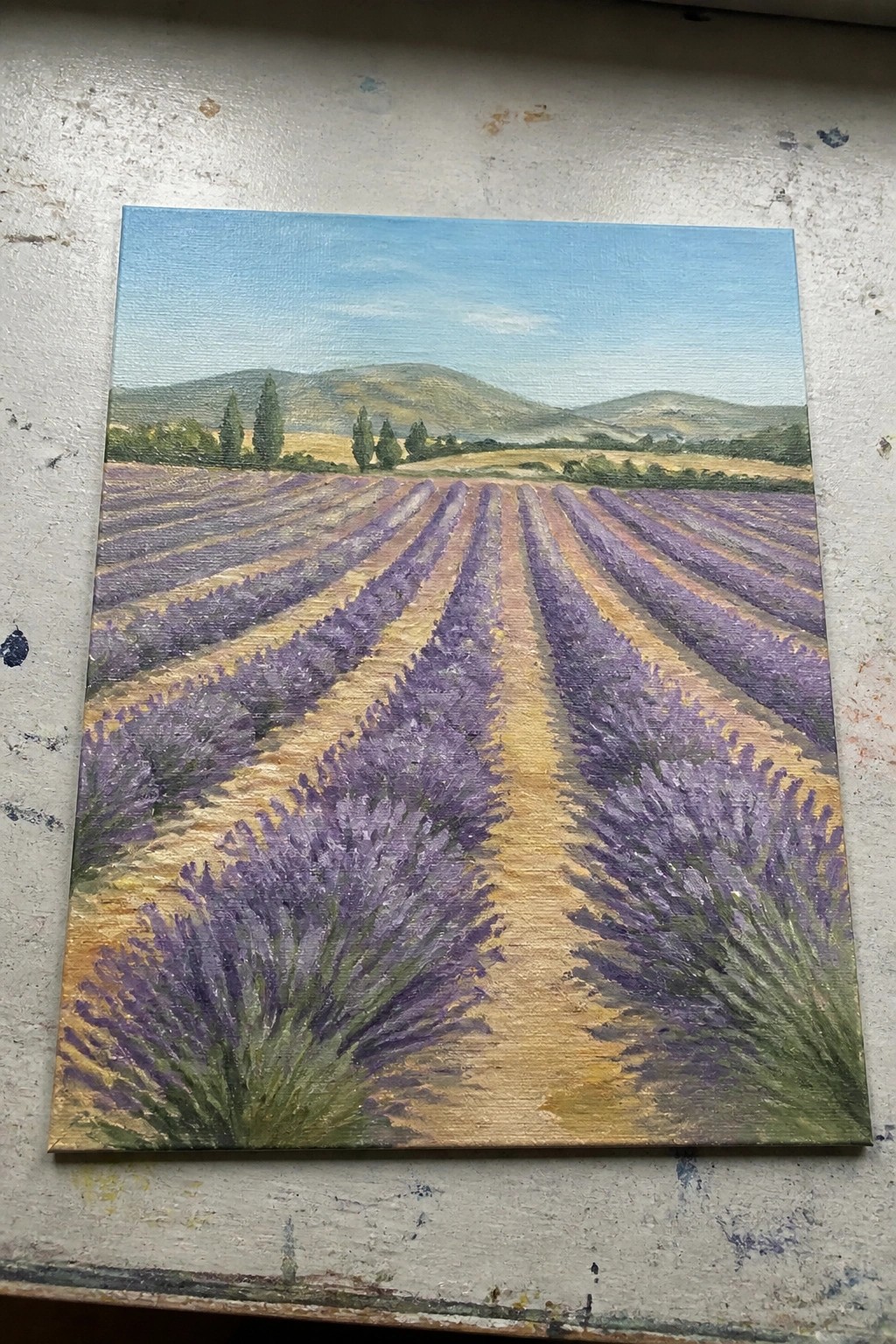 Oil painting of purple lavender rows with central path leading to green hills.