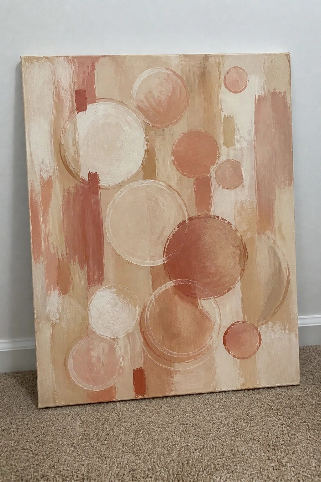 Abstract painting with overlapping circles and vertical lines in warm peach and beige tones