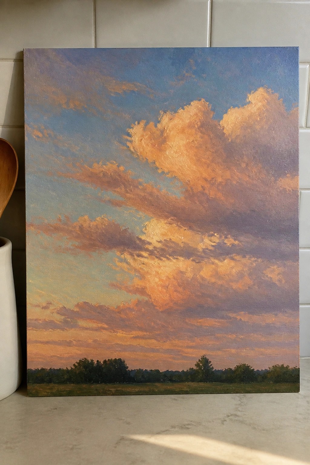 Oil painting depicting a vibrant sunset sky filled with orange and pink clouds above a distant tree line and open field.