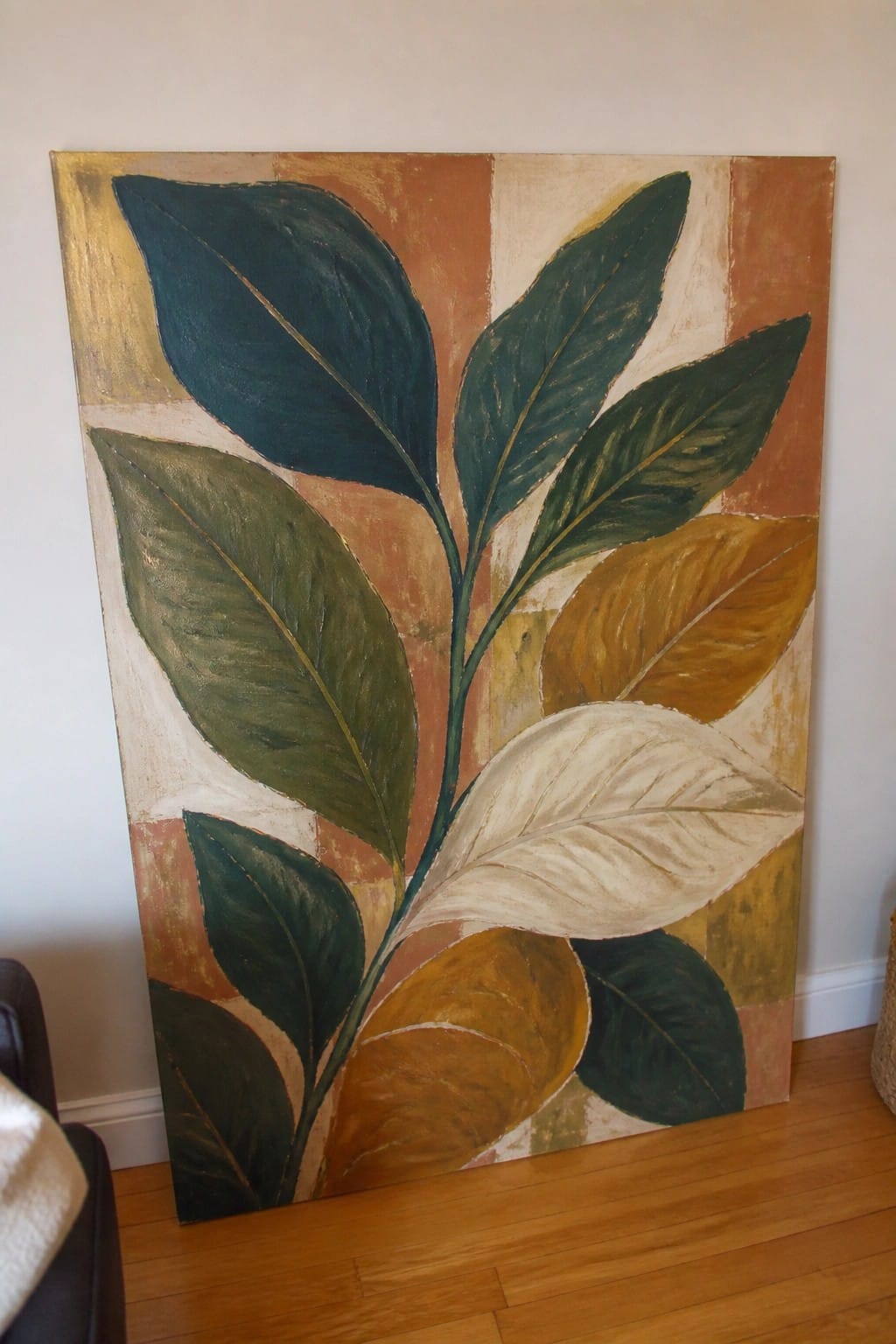 Oversized leaves in green, gold, and white on a striped earthy background.