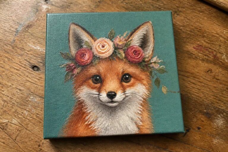 Fox with pink rose crown on teal canvas atop wooden table
