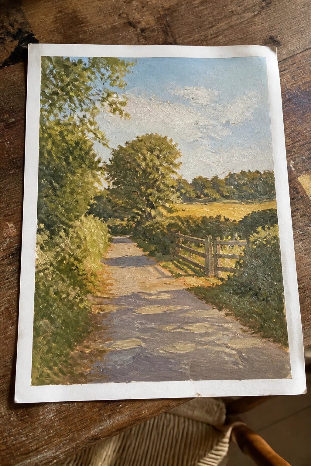 Impressionist oil painting of a sunlit dirt path bordered by green trees and a wooden fence.
