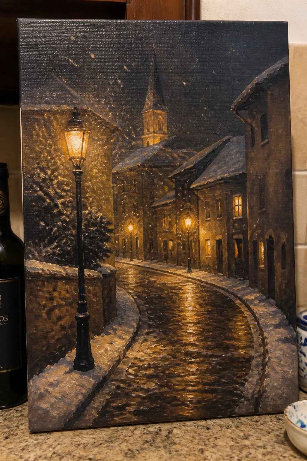 Oil painting of snowy cobblestone street glowing with golden lamplight reflections at night.