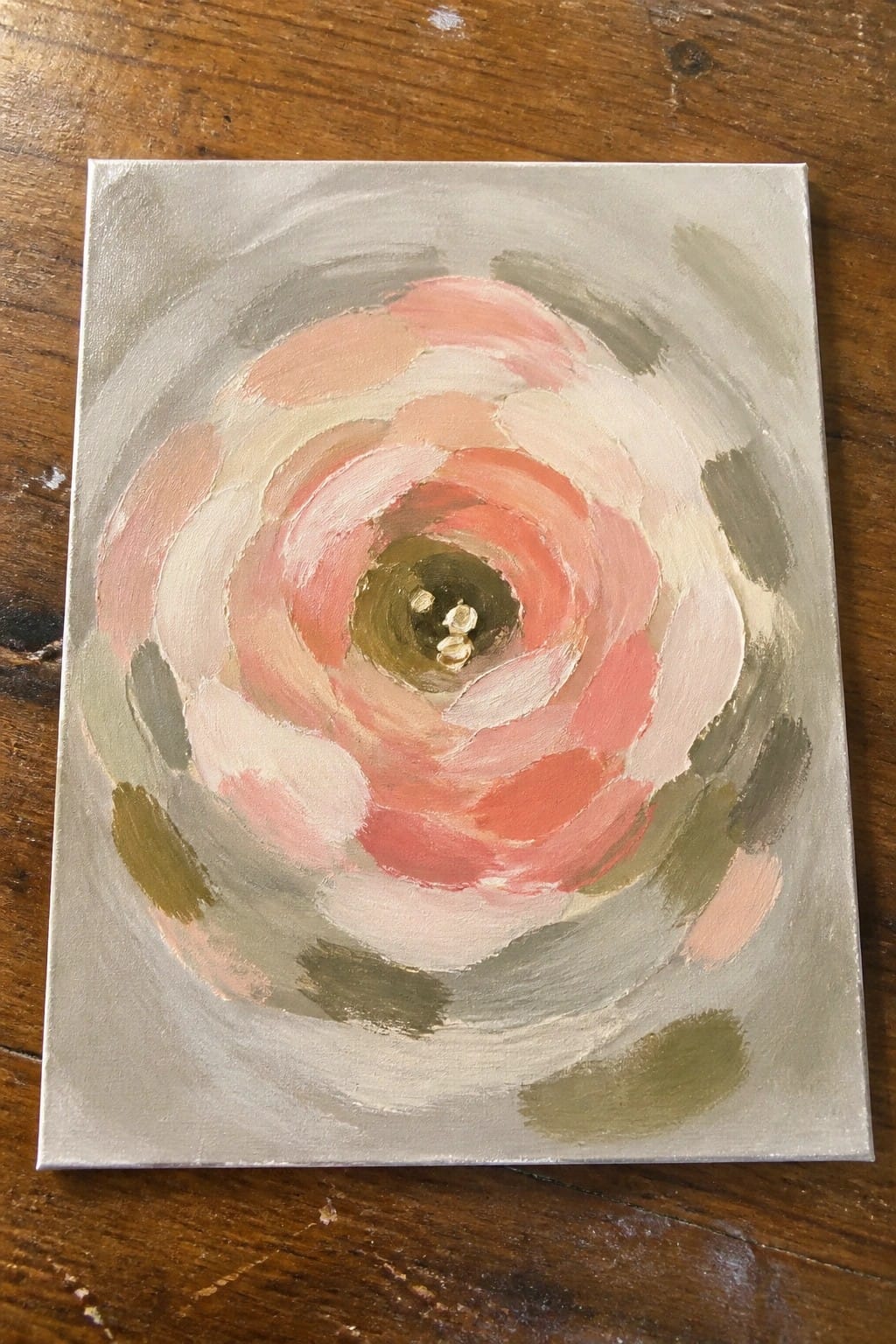Square oil painting of an abstract rose with swirling coral and pink petals on a gray metallic background and a dark center with small gold dots.