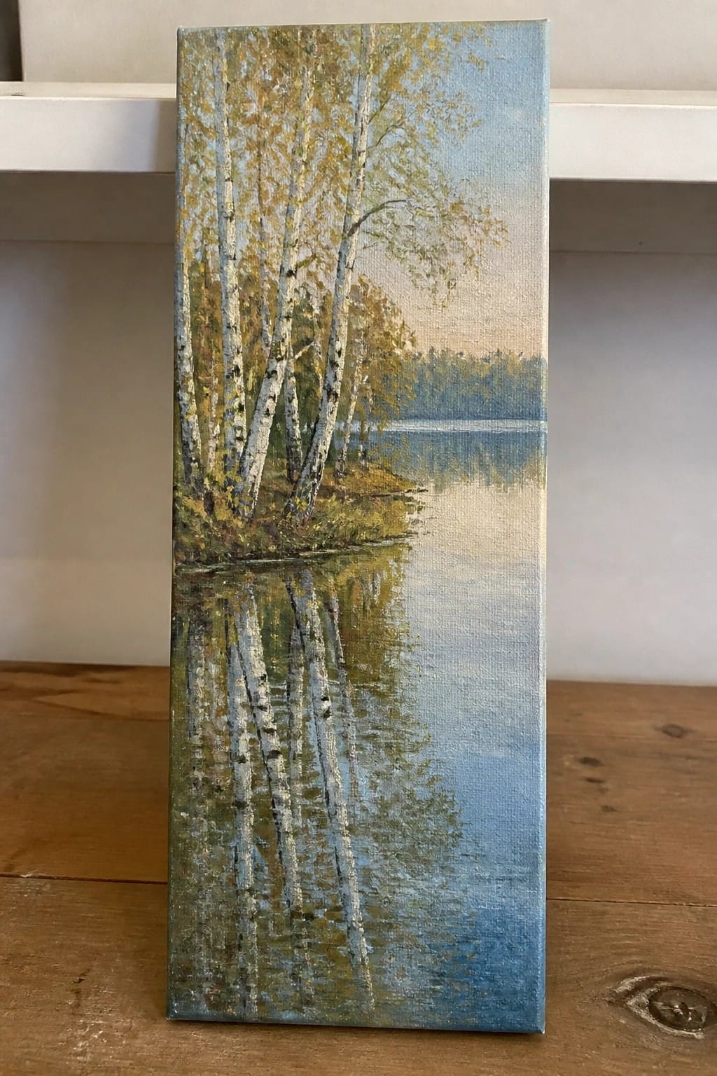 Painting of white birch trees with autumn leaves reflected in a calm lake