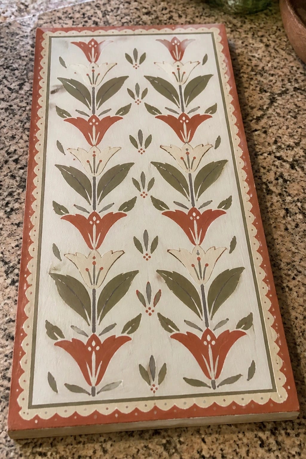 Hand-painted wooden board with red and cream flowers, green leaves, and scalloped red border.