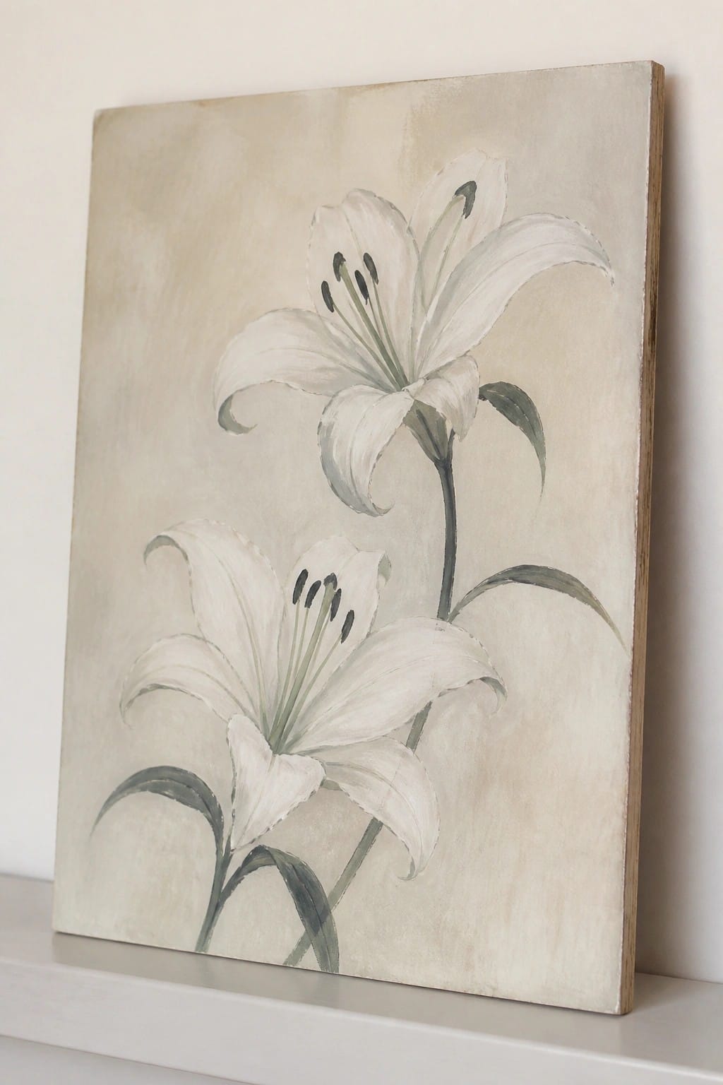 Two white lilies with green stems on a beige canvas against a wall.