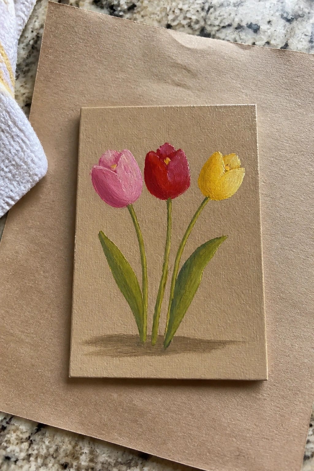 Small canvas with pink, red, and yellow tulips on brown paper