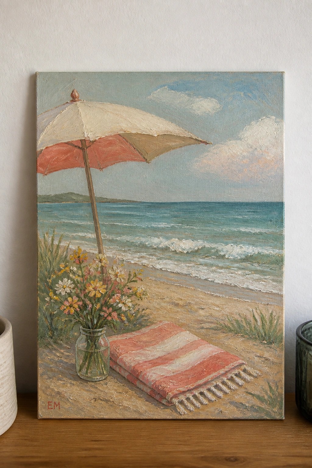 Oil painting of beach umbrella, red-striped towel, and wildflowers in jar by sea.