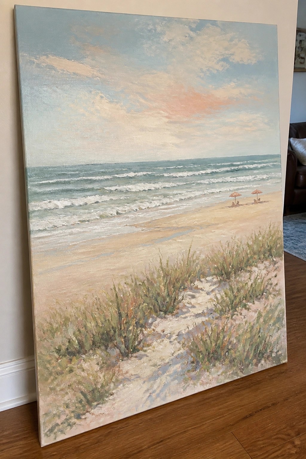 Impressionistic beach painting with turquoise waves, sandy shore, grassy dunes, and distant umbrellas.