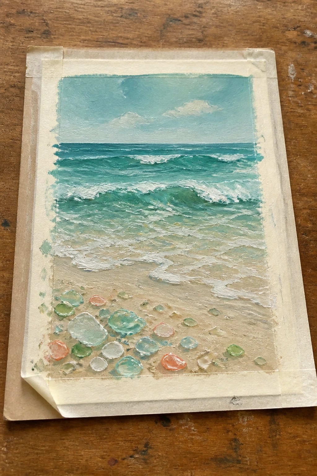 Seascape painting of teal waves on sandy beach with colorful sea glass pebbles