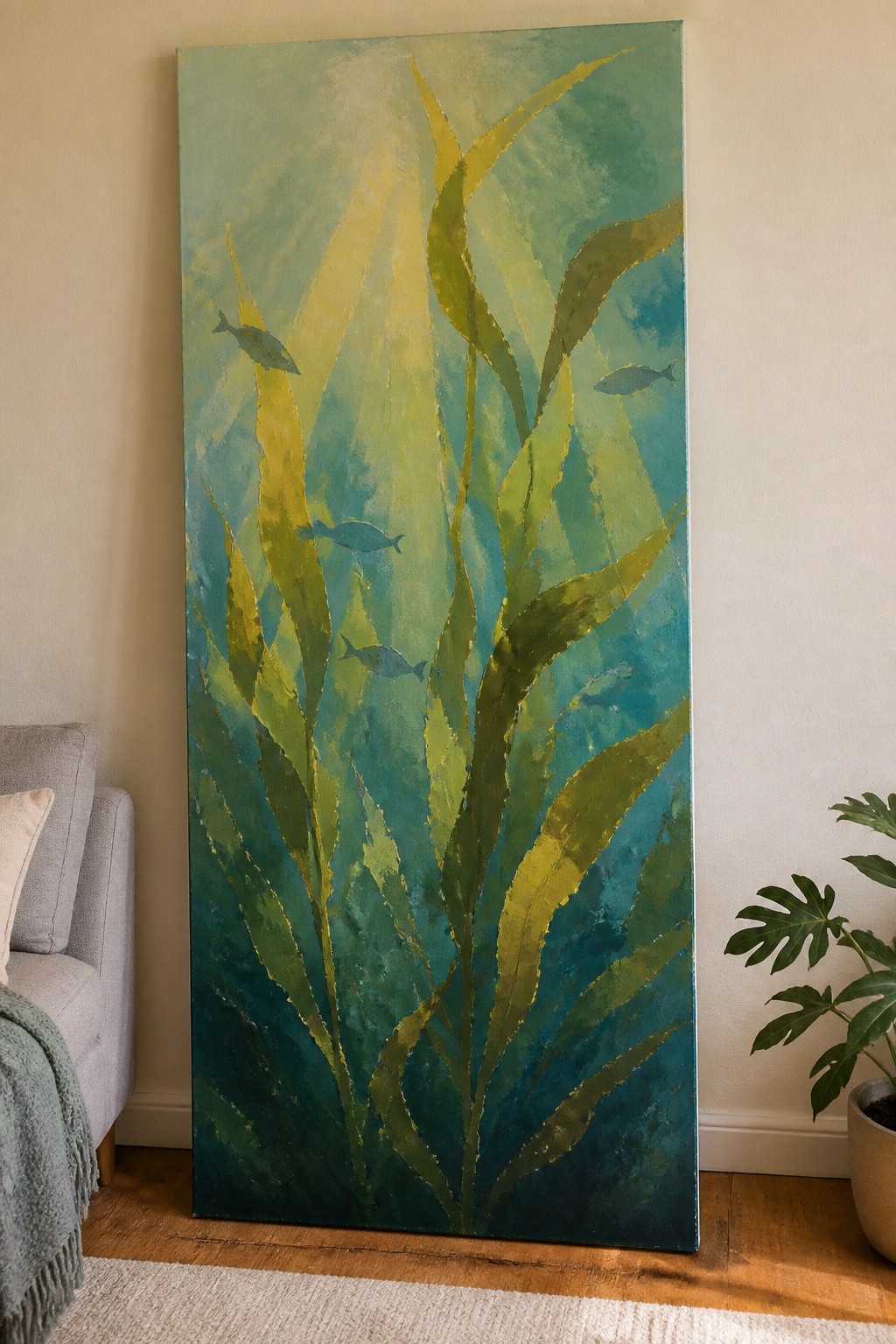 Abstract painting of green seaweed and fish in blue-green ocean hues, leaning in living room.