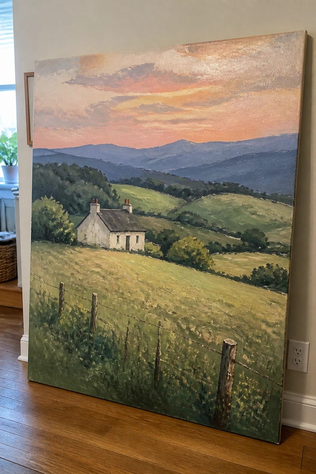 Large landscape painting of white cottage in green fields under vibrant sunset sky.