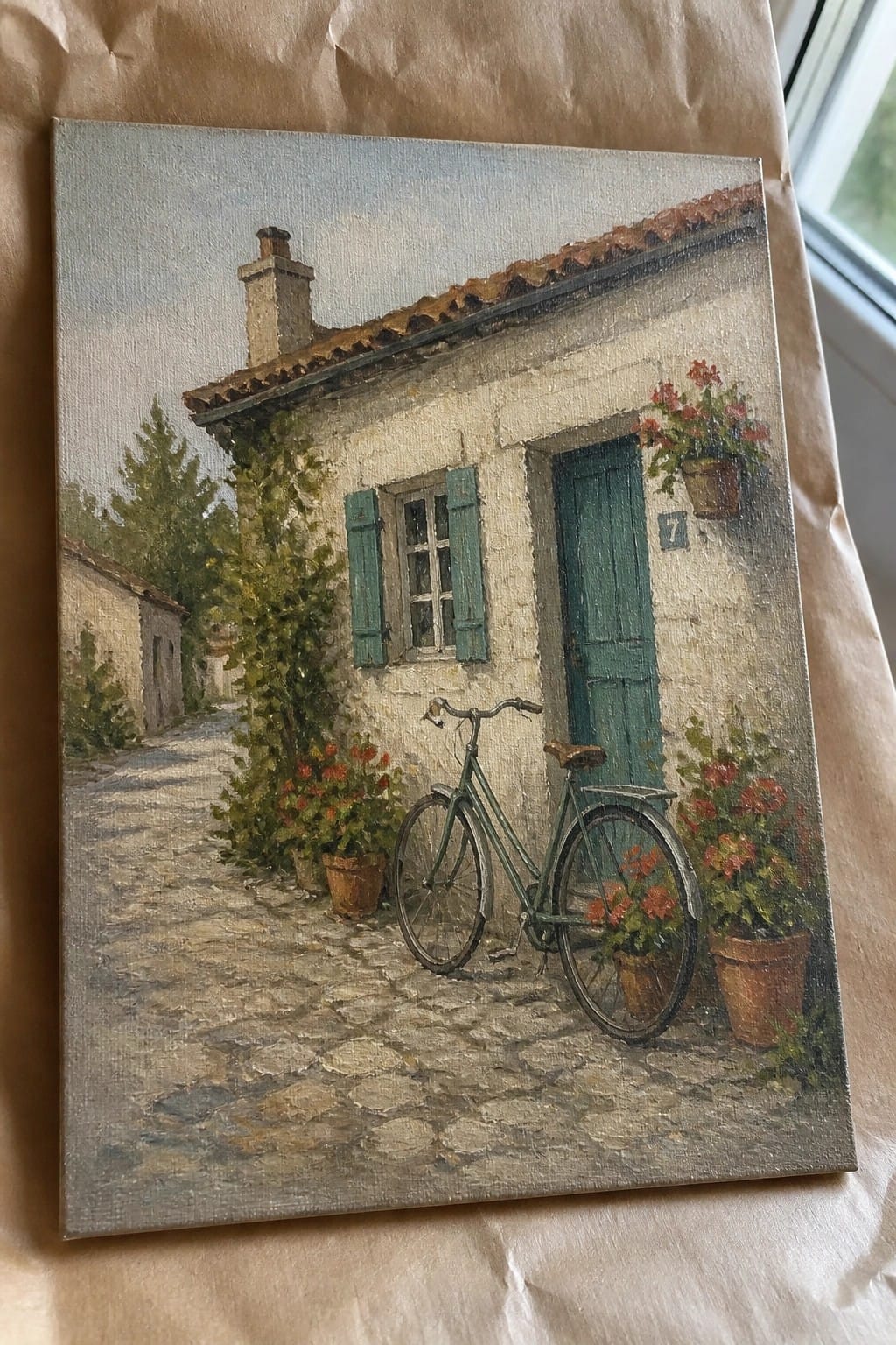Green bicycle parked by white house with green door, shutters and red flower pots on cobblestones