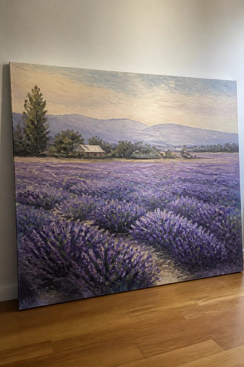 Large painting of purple lavender fields with mountains and barn on wall.