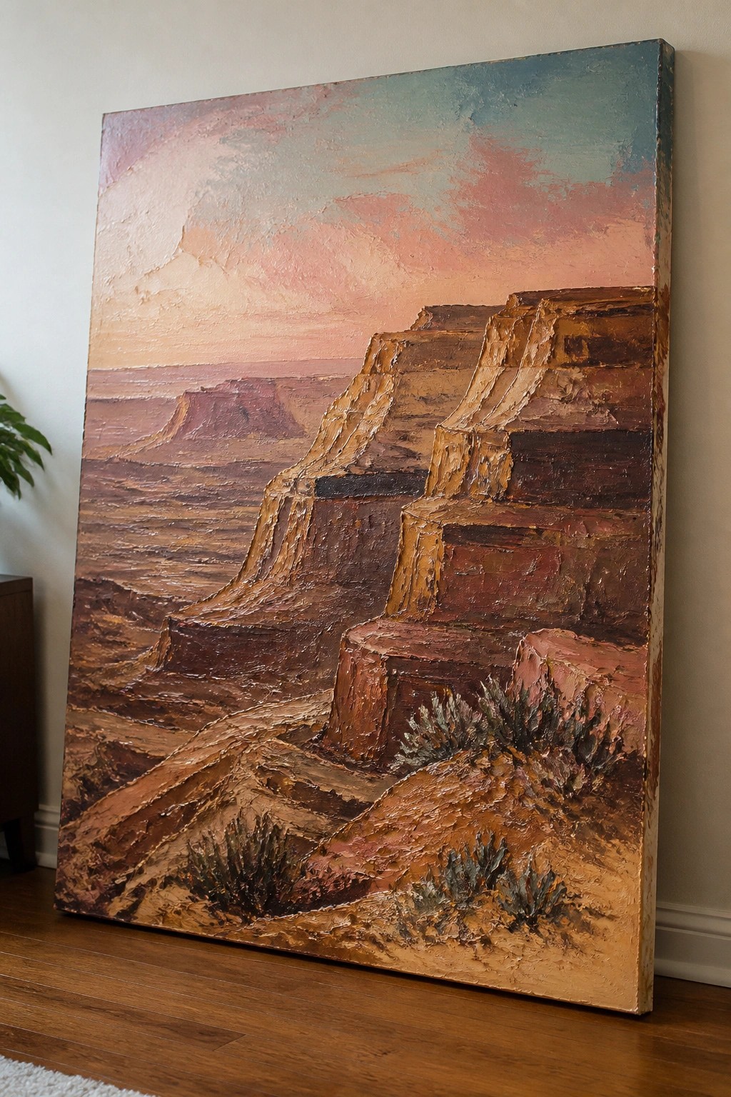 Textured oil painting of layered canyon cliffs under a pink-blue sky, leaning on a wall