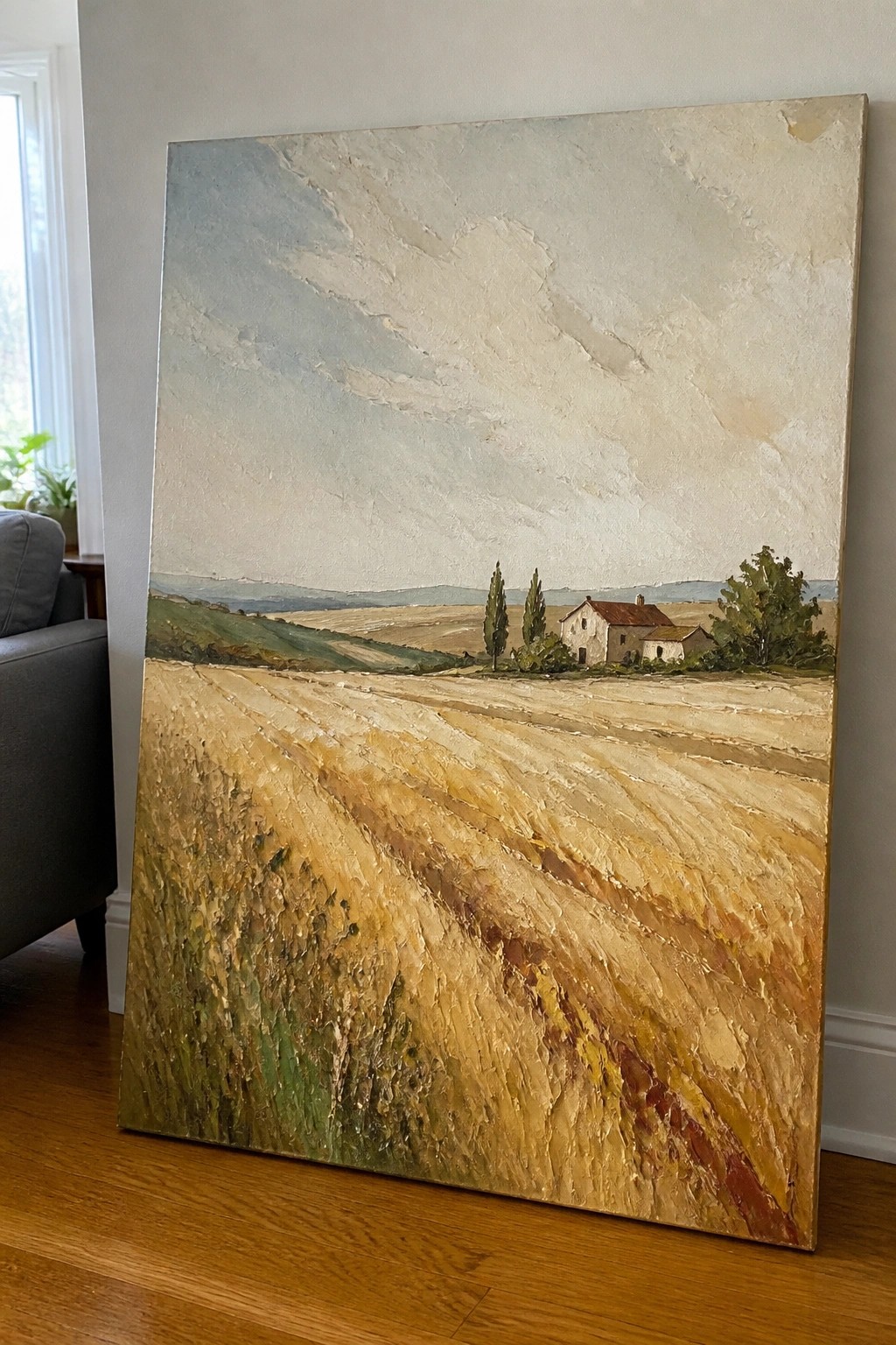 Impasto painting of golden wheat field with farmhouse, trees, and rolling hills.