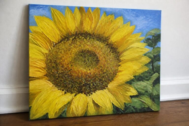 Vibrant yellow sunflower painting with brown center, green leaves, and blue sky background