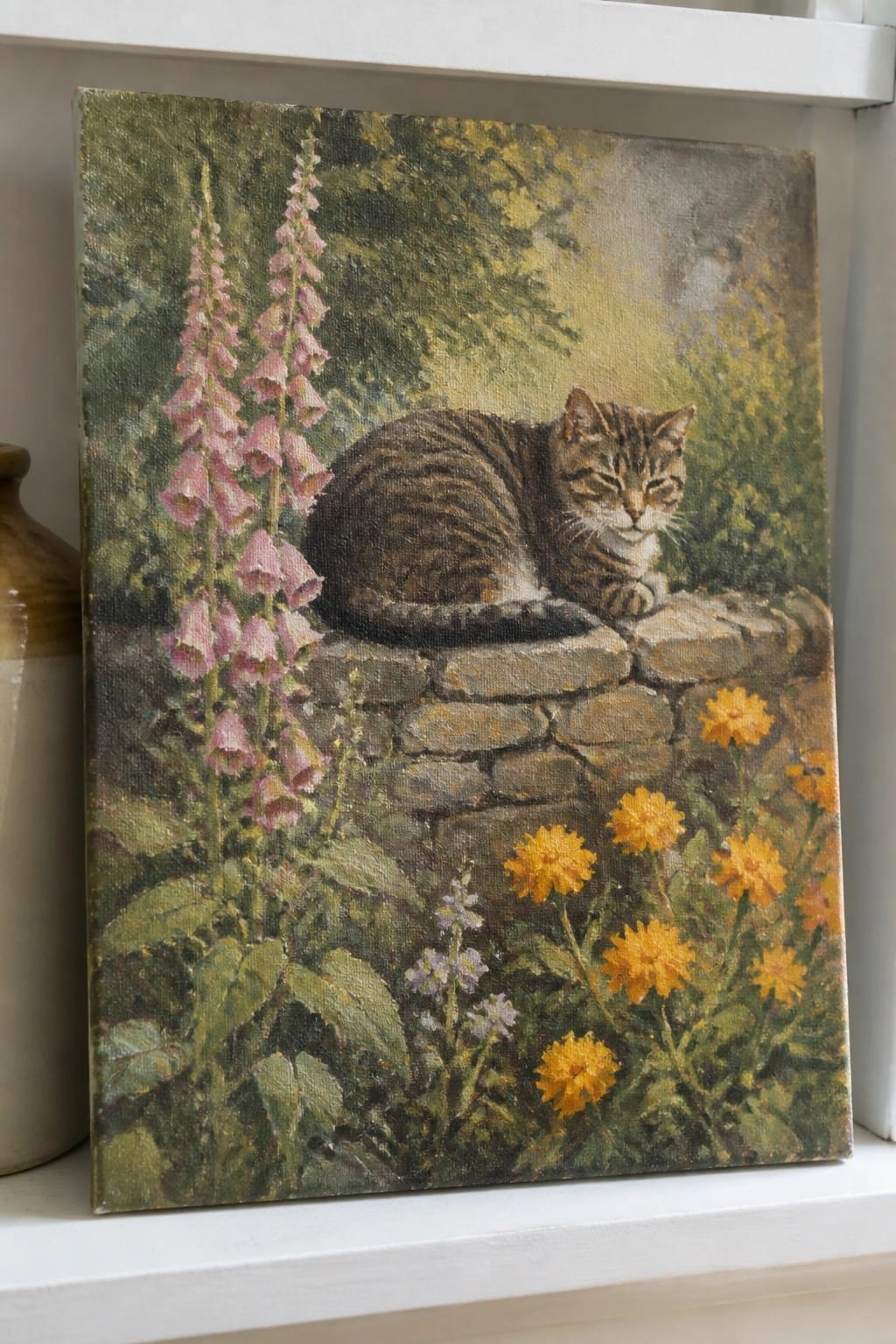 Tabby cat resting on stone wall amid pink foxgloves and yellow flowers in garden painting