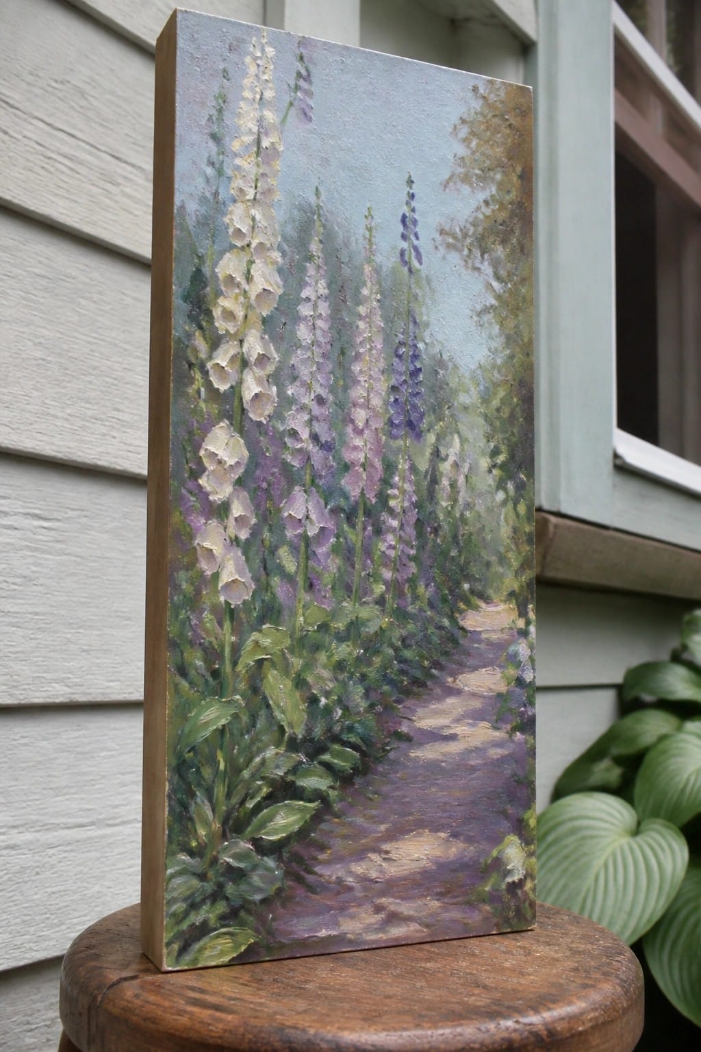 Impressionistic oil painting of purple and white foxgloves along a garden path on a stool