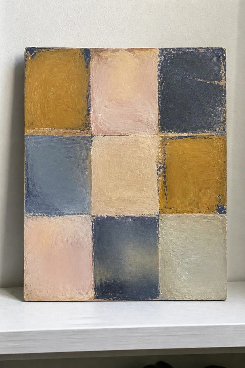 Abstract painting of a 3x3 grid with muted yellow, blue, pink, and beige squares.