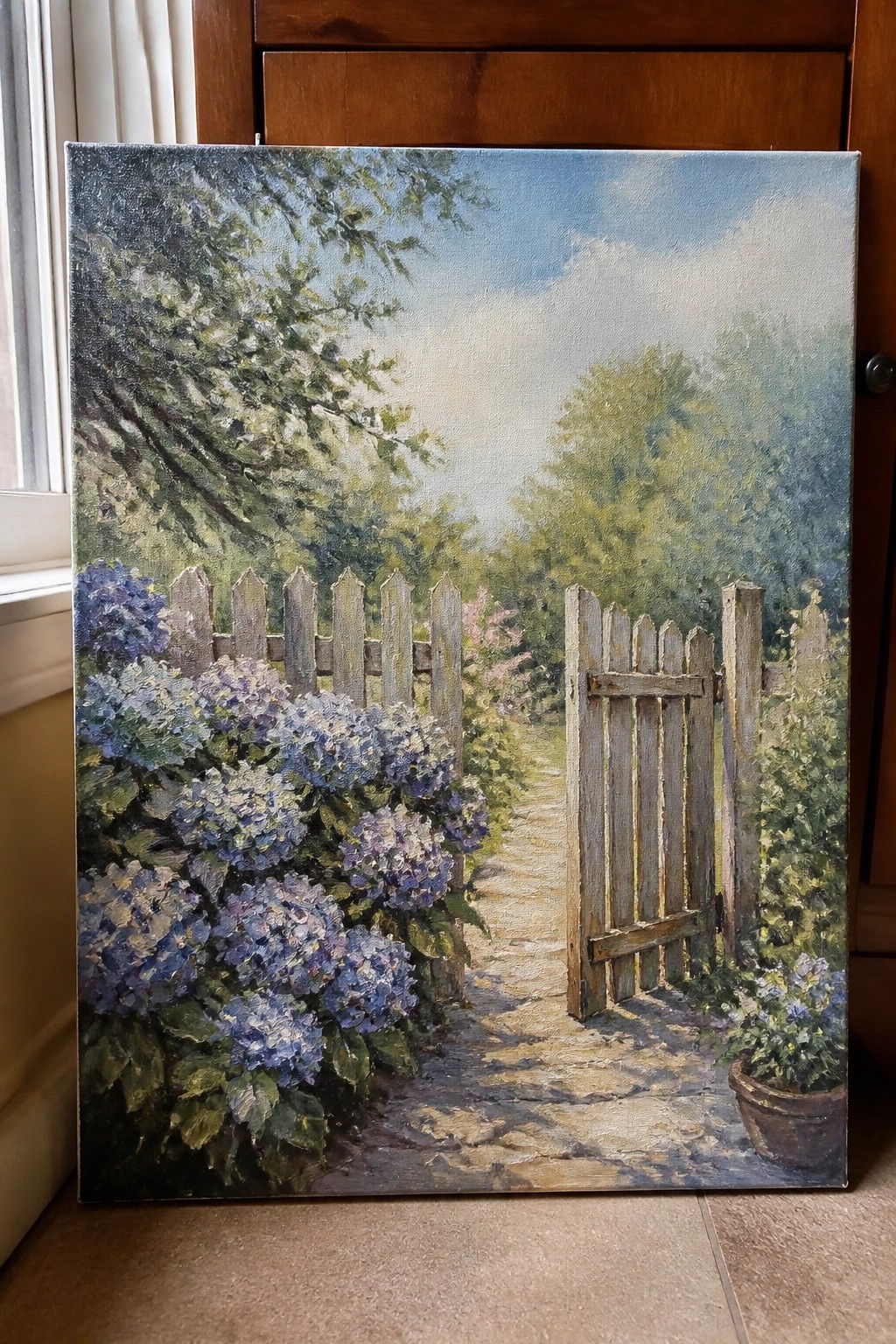 Lush garden with blooming blue hydrangeas, open wooden gate, and winding stone path