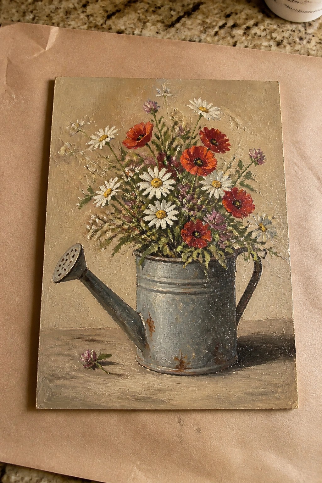 Still life of red poppies and white daisies in a rustic metal watering can.