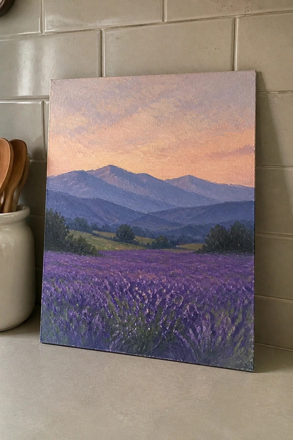 Canvas painting of purple lavender field with blue mountains under pink-orange sunset on kitchen counter