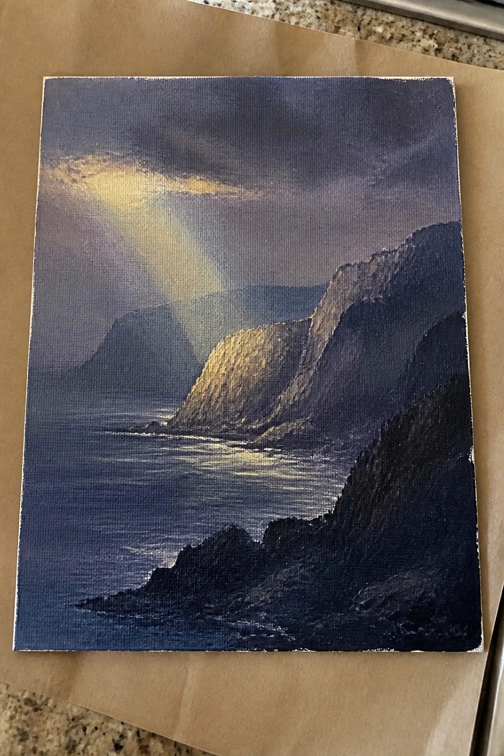 Dramatic painting of steep coastal cliffs by a dark sea with golden sunlight piercing clouds.