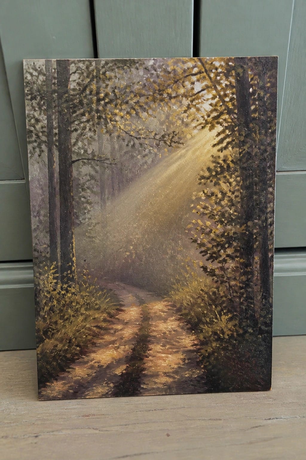 Sunlit path winds through misty forest with golden rays piercing trees
