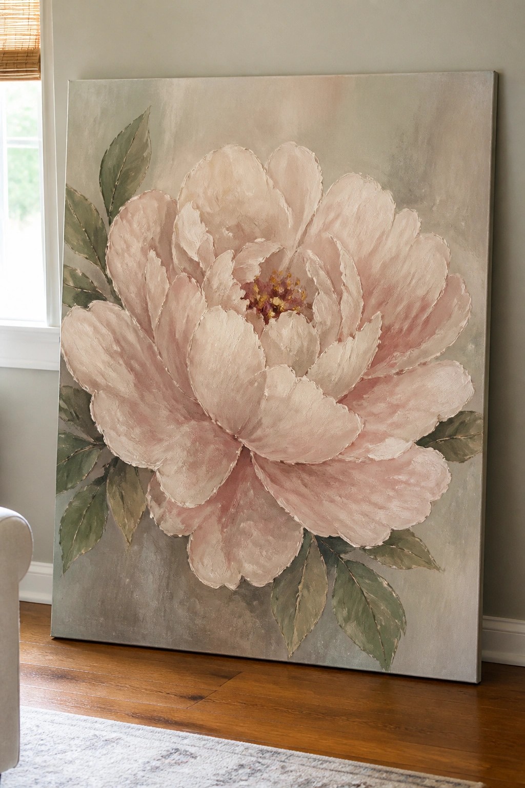 Large pink peony painting with green leaves on textured canvas leaning on floor