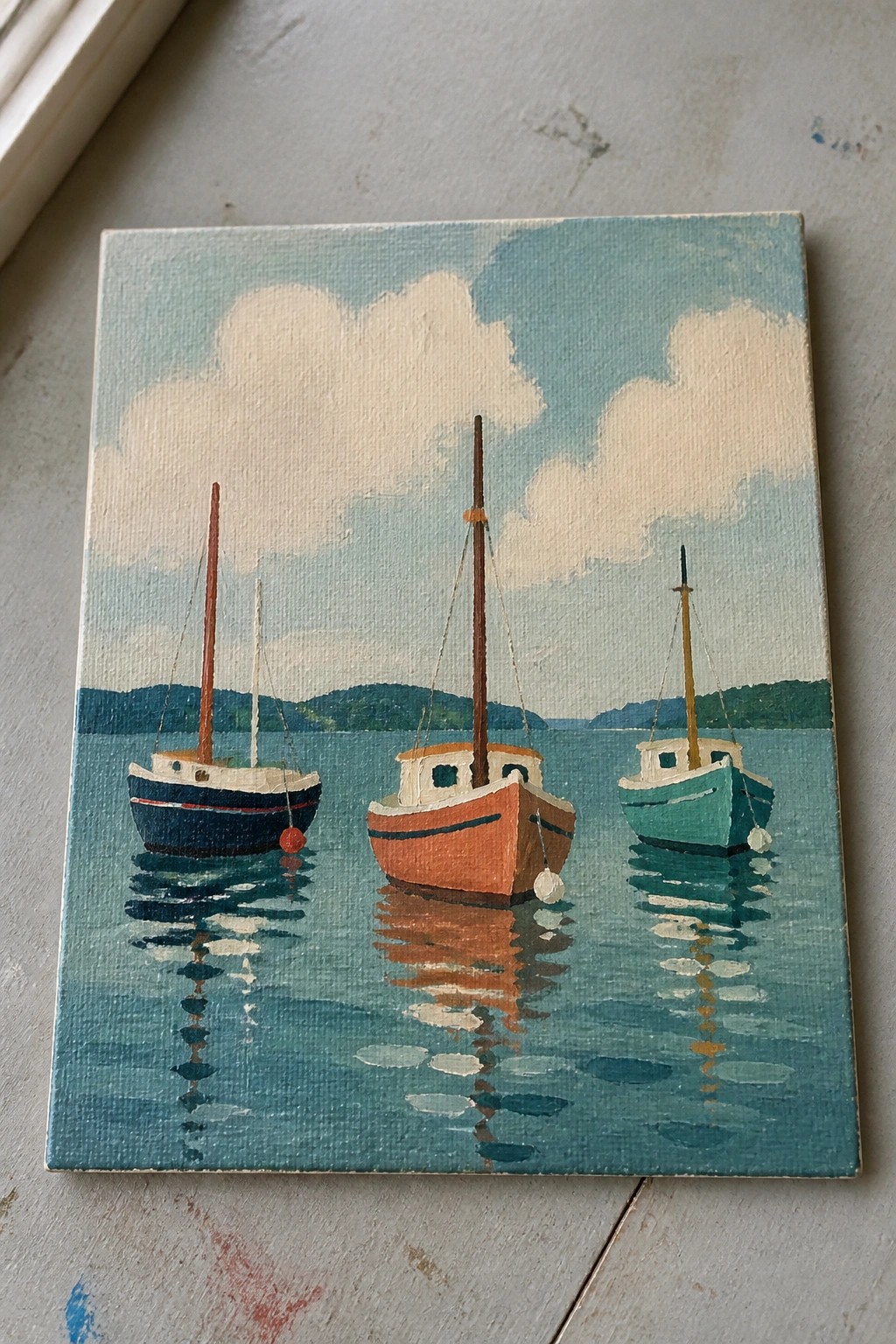 Three colorful boats moored on calm blue water with sky reflections and distant hills.