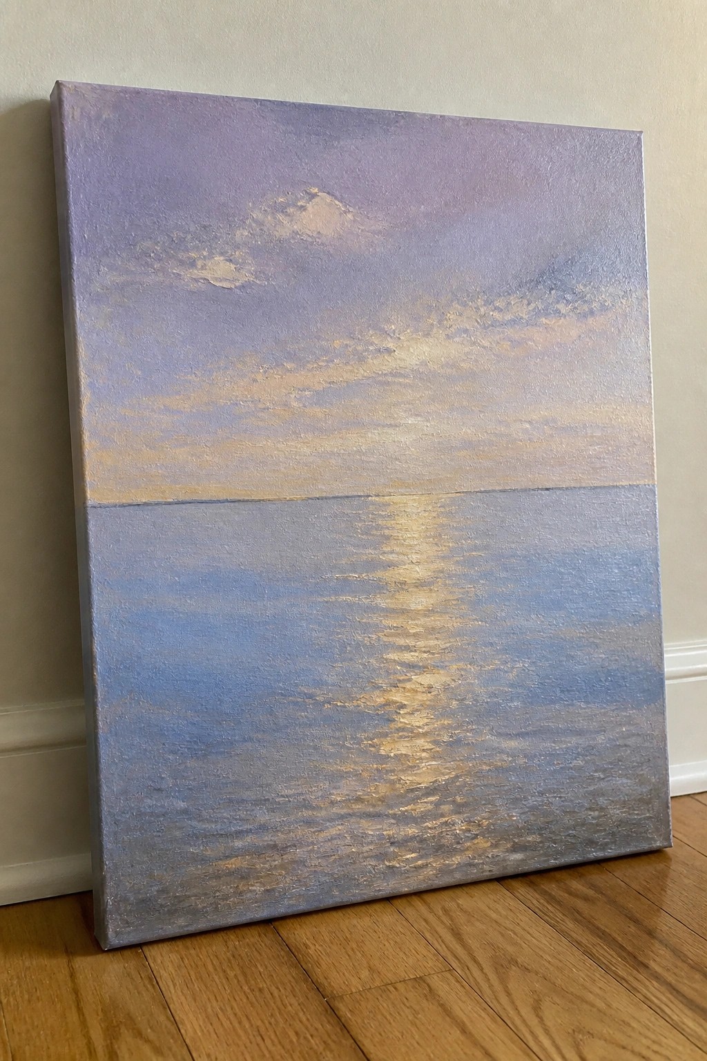 Abstract painting of purple sky over blue sea with golden light reflection, leaning against wall.