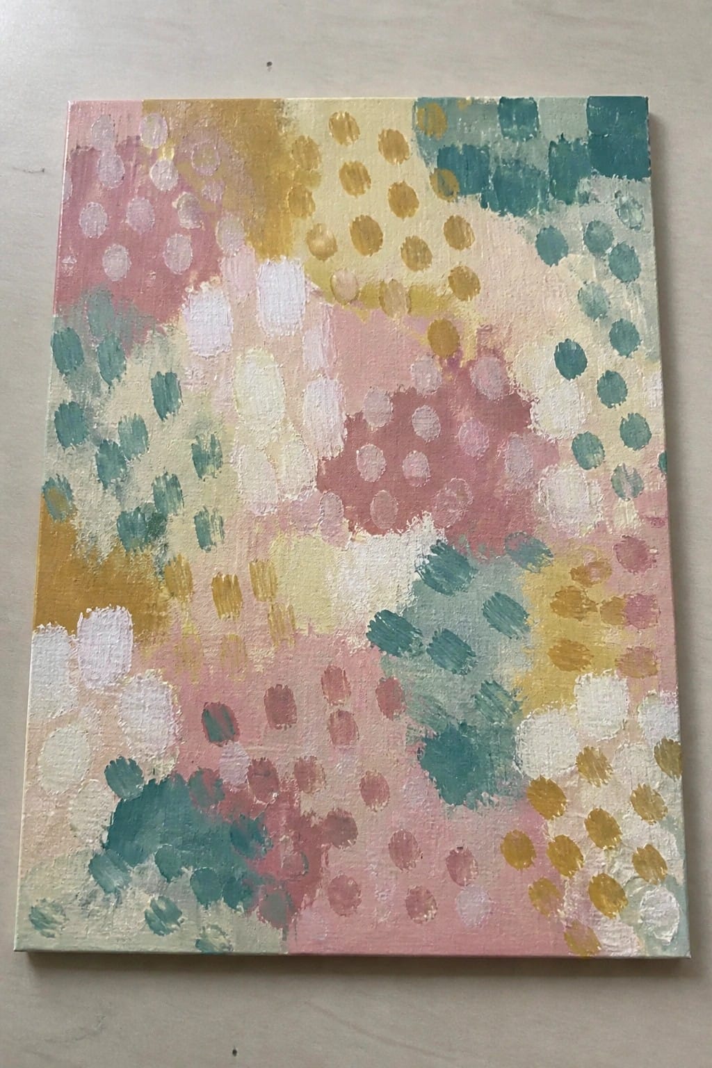 Abstract painting with pastel pink, yellow, teal, and white dots and strokes
