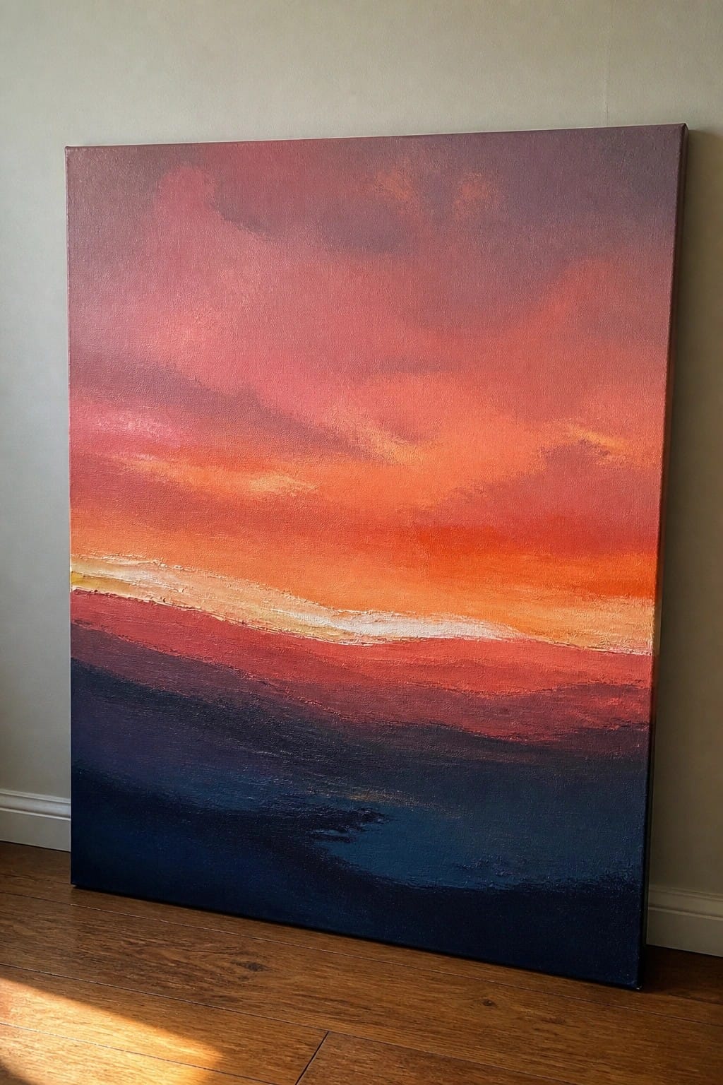 Abstract painting of vibrant sunset with red-orange gradients leaning on wooden floor