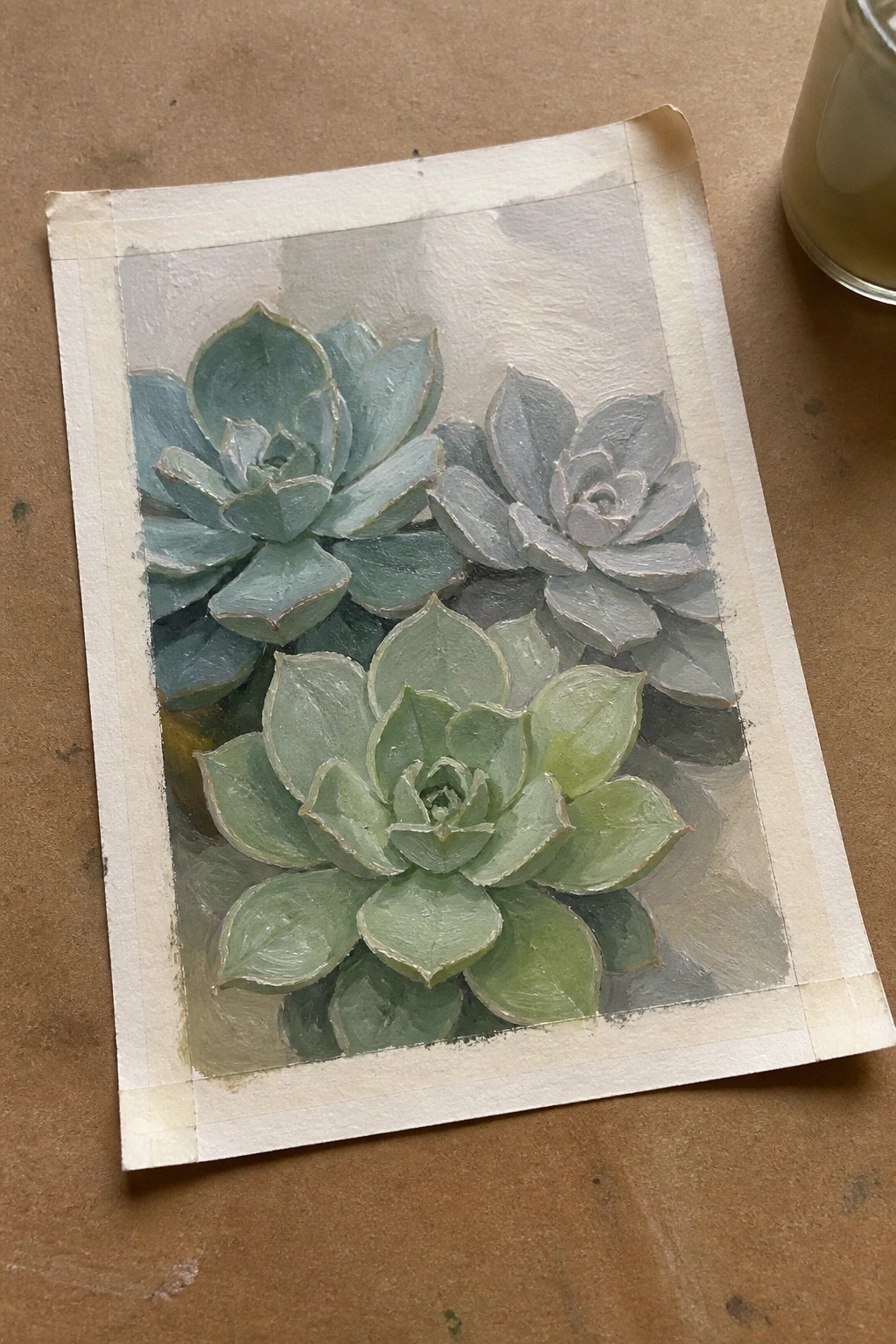 Three painted succulents in teal, green, and gray on taped paper.