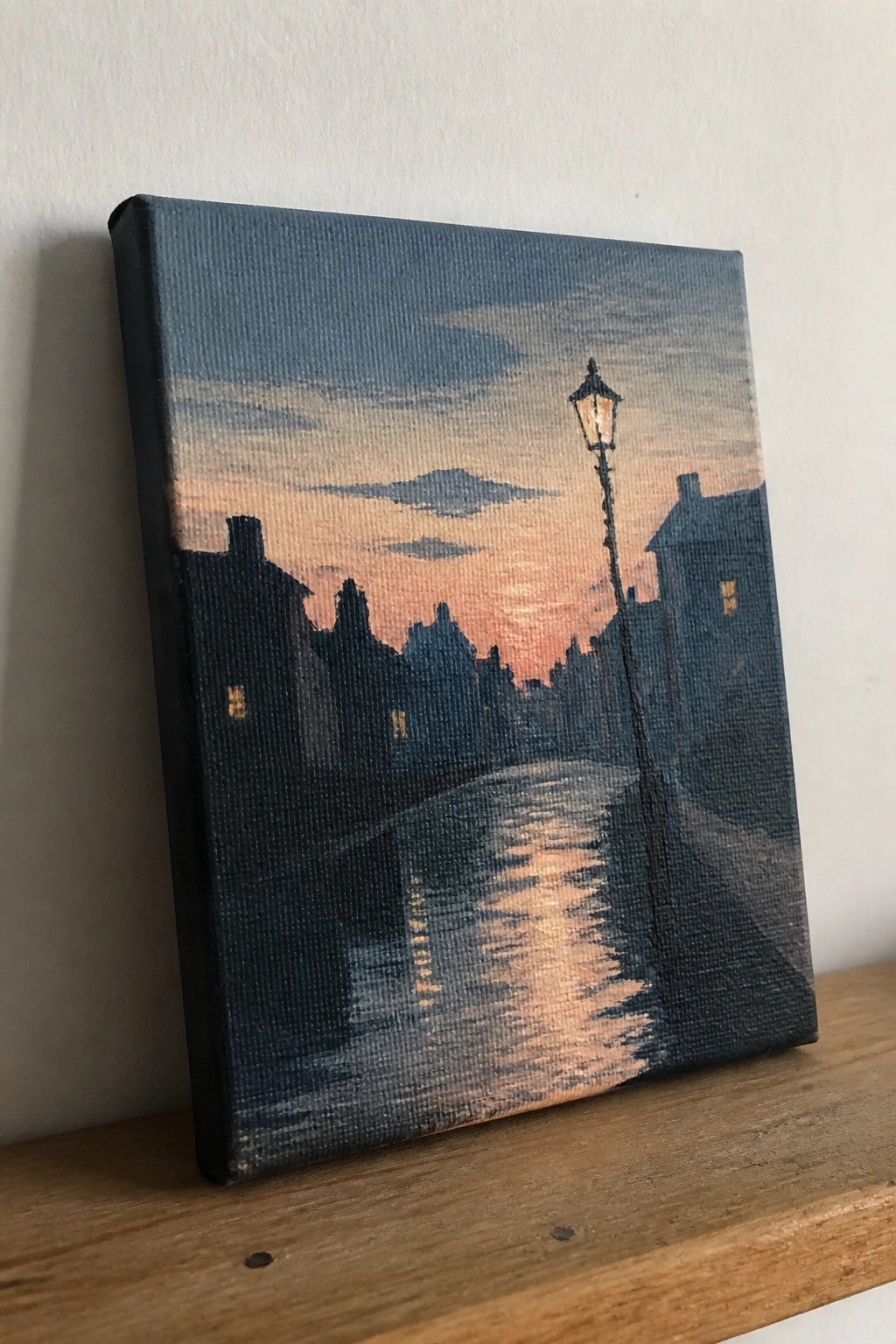 Canvas painting of twilight street with glowing lamppost, silhouetted buildings, and sky reflections