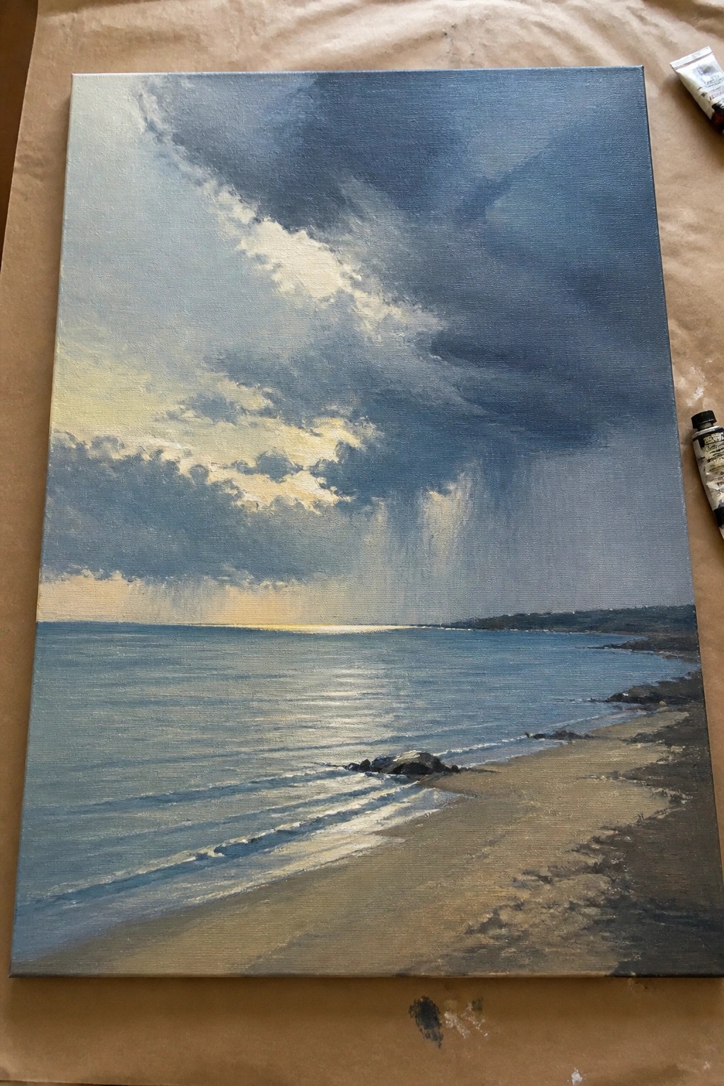 Oil painting of stormy beach with dark clouds, waves, and sandy shore on canvas.