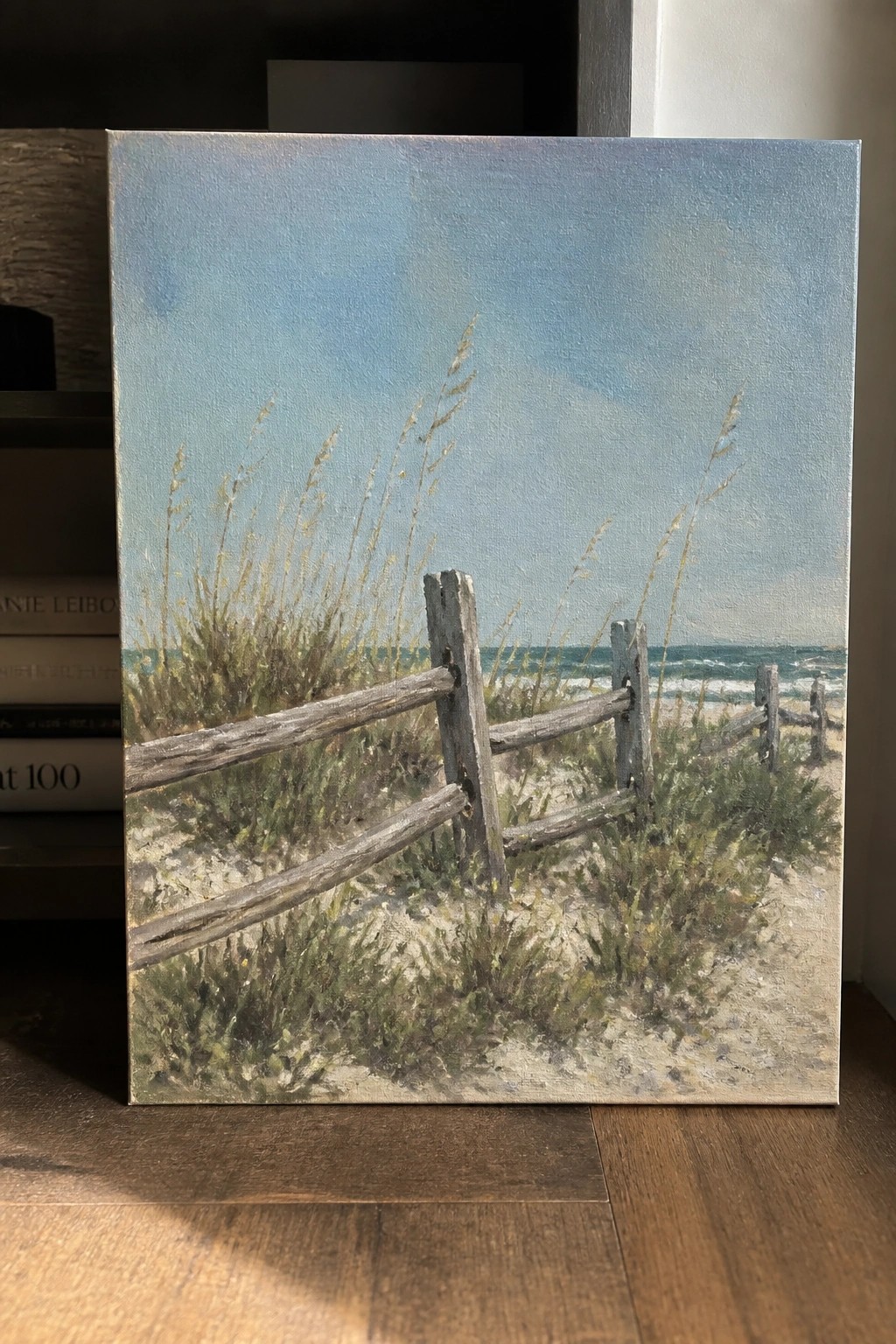 Coastal painting of weathered wooden fence amid grassy dunes overlooking the ocean.
