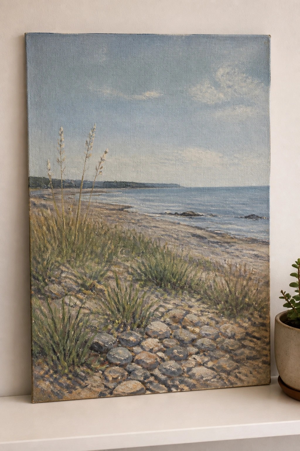 Landscape painting of rocky beach path, grasses, and calm blue sea under cloudy sky