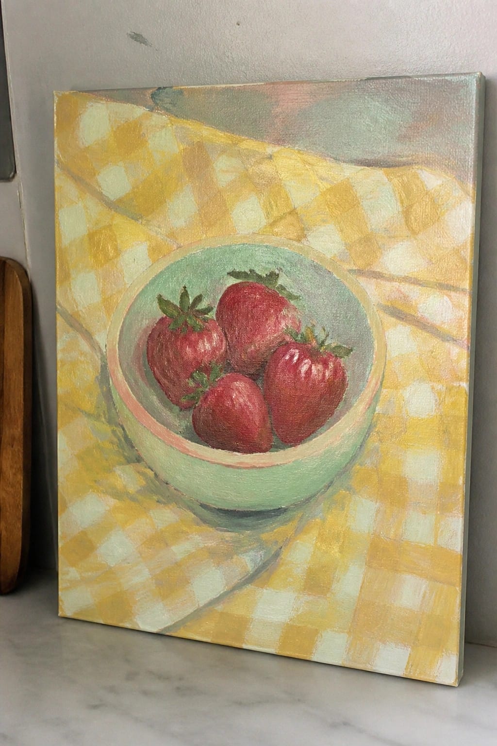 Four strawberries in green bowl on yellow checkered cloth painting