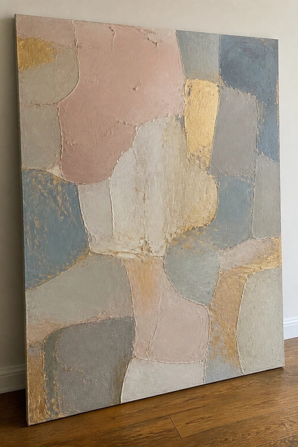 Abstract painting with irregular pastel shapes in pink, blue, beige, and gold on canvas