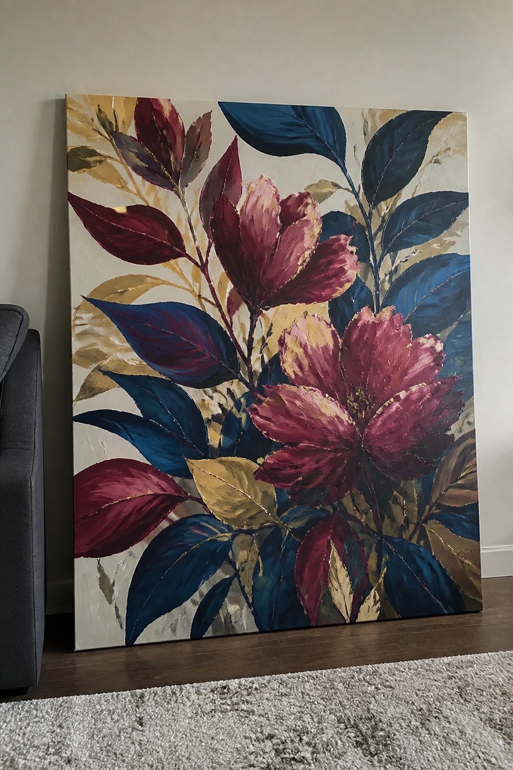 Large abstract floral painting with red blooms, blue leaves, and gold accents leaning on floor